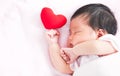 Cute asian newborn baby girl sleeping with red heart Royalty Free Stock Photo