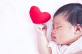 Cute asian newborn baby girl sleeping with red heart Royalty Free Stock Photo