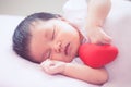 Cute asian newborn baby girl sleeping with red heart Royalty Free Stock Photo