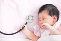 Cute asian newborn baby girl smiling and holding stethoscope Royalty Free Stock Photo