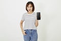 Cute asian short brunette hair woman promotes smartphone app mockup of blank screen, woman blogger showing personal social media Royalty Free Stock Photo