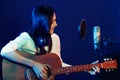 A cute Asian singer and musician playing guitar and sing a song for recording in voice studio Royalty Free Stock Photo