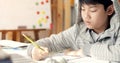 Cute asian teen boy doing your homework at home. Royalty Free Stock Photo