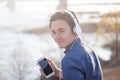 Cute Asian teen boy listening to music on headphones in his phone, smiling enjoying the view Royalty Free Stock Photo