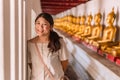 Cute Asian teen smile happy travel in temple with buddha row background