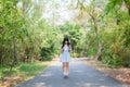 A cute Asian Thai girl is standing on a forest path alone