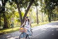 Cute Asian Thai girl in vintage clothing is riding a bicycle in the sunny summer park Royalty Free Stock Photo