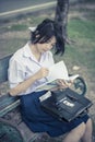 Cute Asian Thai schoolgirl student in high school uniform is sit Royalty Free Stock Photo