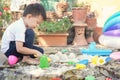 Cute Asian toddler boy playing with sand alone at home, Kid playing with sand toys in urban home garden , Montessori education, Royalty Free Stock Photo