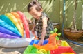 Cute Asian toddler girl having fun playing with water table at home, Wet Pouring Montessori Preschool Practical Life Activities, Royalty Free Stock Photo