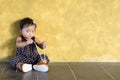 Cute asian toddler try to tying / wear her own brown shoes. Royalty Free Stock Photo