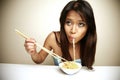 Cute Asian woman eating noodles