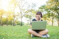 Asian woman using on smart phone and laptop with feeling relax and smiley face. Royalty Free Stock Photo