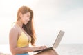 Cute Asian woman working with computer laptop on the tropical island beach Royalty Free Stock Photo