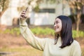 Cute Asian women are using their phones to take selfies and smile happy in the garden at home