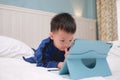 Cute Asian 3 - 4 years old toddler boy child playing game, watching cartoon, using tablet pc computer, Gadget addicted children,