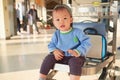 Cute Asian 2 years old toddler boy child with suitcase, sitting on trolley at airport, Family travel & vacation with kid concept Royalty Free Stock Photo