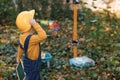 Cute asian young kid builder boy wearing protective yellow helmet on background construction cranes on site. Future Royalty Free Stock Photo