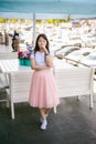 Cute asian young woman in summer cafe outdoors. girl In white T-shirt, with long hair in simple light cozy interior of restaurant Royalty Free Stock Photo