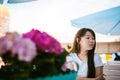 Cute asian young woman in summer cafe outdoors. girl In white T-shirt, with long hair in simple light cozy interior of restaurant Royalty Free Stock Photo