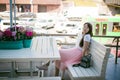 Cute asian young woman in summer cafe outdoors. girl In white T-shirt, with long hair in simple light cozy interior of restaurant Royalty Free Stock Photo