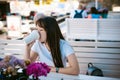 Cute asian young woman in summer cafe outdoors. girl In white T-shirt, with long hair in simple light cozy interior of restaurant Royalty Free Stock Photo