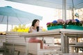 Cute asian young woman in summer cafe outdoors. girl In white T-shirt, with long hair in simple light cozy interior of restaurant Royalty Free Stock Photo