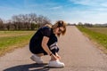 cute athlete woman tying her shoes during a workout on a country road Royalty Free Stock Photo