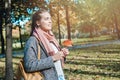 Cute autumn woman holding red maple leaf outdoors. Royalty Free Stock Photo