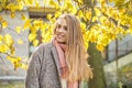 Cute autumn woman holding yellow maple leaf outdoors. Romantic girl with long hair in fall park Royalty Free Stock Photo