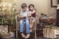 Cute babies boy and girl in a chair reading a book in a interior Royalty Free Stock Photo