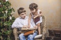 Cute babies boy and girl in a chair reading a book in a interior Royalty Free Stock Photo