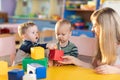 Cute babies play with blocks. Educational toys for preschool and kindergarten child. Little boys build block toys at Royalty Free Stock Photo