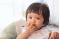 Cute baby asian child girl eating healthy food by herself