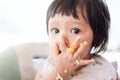 Cute baby asian child girl eating healthy food by herself Royalty Free Stock Photo