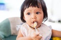 Cute baby asian child girl eating healthy food by herself Royalty Free Stock Photo