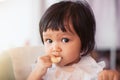 Cute baby asian child girl eating healthy food by herself Royalty Free Stock Photo