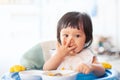 Cute baby asian child girl eating healthy food by herself Royalty Free Stock Photo