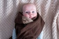 Cute baby with big blue eyes wearing a hat and a huge knitted scarf Royalty Free Stock Photo