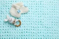 Cute baby booties and toy on light blue knitted fabric, flat lay. Space for text Royalty Free Stock Photo