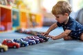 Cute baby boy building cars in row on the floor and playing with them. Stereotypical alignment of objects is a sign of autism.