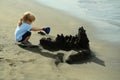 Cute baby boy builds sandcastle on sea beach Royalty Free Stock Photo