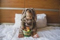 Cute baby boy in the bunny costume playing with the basket with colorful easter eggs. Easter egg hunt and baby development Royalty Free Stock Photo