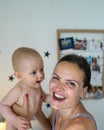 A cute baby boy on a changing table with his attractive mommy Royalty Free Stock Photo