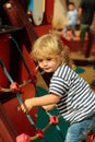 Cute baby boy climbing rope net or ladder Royalty Free Stock Photo