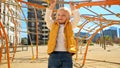 Cute baby boy climbing on the rope nets and running at playground. Children playing outdoor, kids outside, summer holiday and Royalty Free Stock Photo