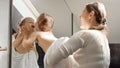 Cute baby boy covered in bath towel with mother looking in his reflection in mirror. Concept of parenting, happiness and child