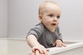 Cute baby boy in a crib. Adorable infant kid staying in a cot. Royalty Free Stock Photo