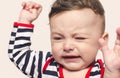 Cute baby boy crying raising his hands up. Royalty Free Stock Photo