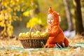 Cute baby boy dressed in fox costume sitting by basket with apples Royalty Free Stock Photo